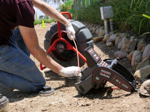 Image showing a worker inserting a plumbing diagnostic camera down a pipe